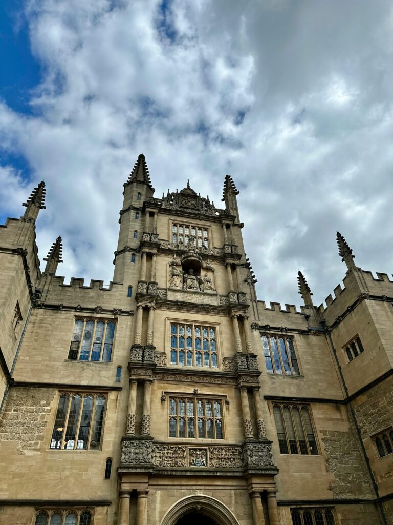 Majestic view of the Bodleian Library's Gothic architecture at Oxford University under a cloudy sky.